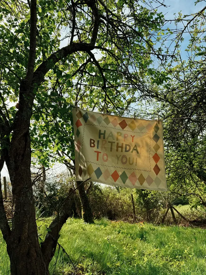 Heirloom Fabric Birthday Banner, hanging in a tree. 