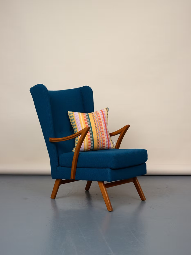 aoife square cushion. a multi coloured patterned square cushion photographed on a blue chair.