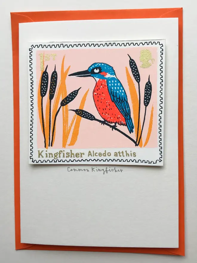 Bird Stamp Card British/ Common Kingfisher Stamp, a white card with a common kingfisher stamp in the centre against an orange envelope on a white background. 