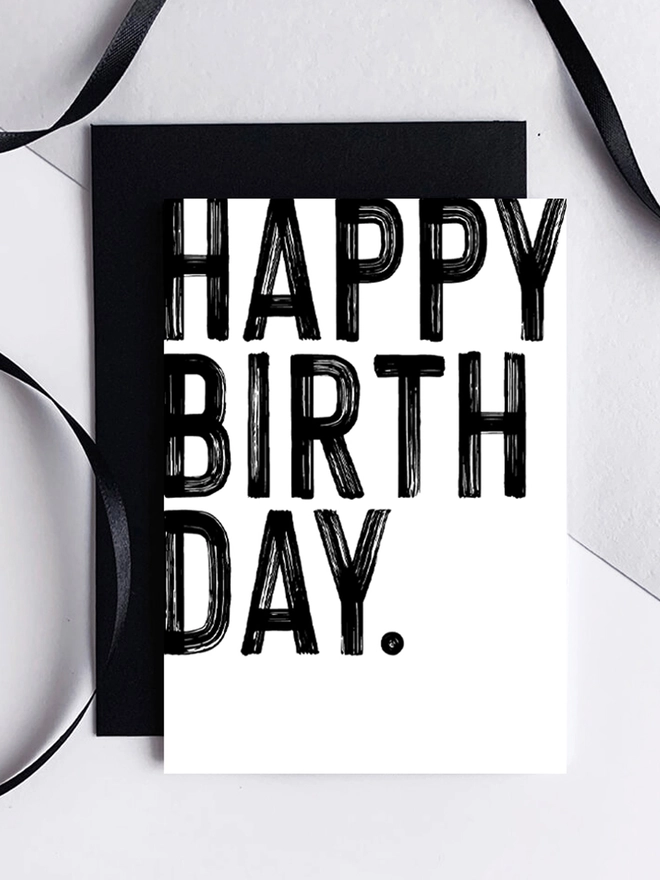 Black and white Happy Birthday Card with ribbon. Text is in a brushstroke thick font.