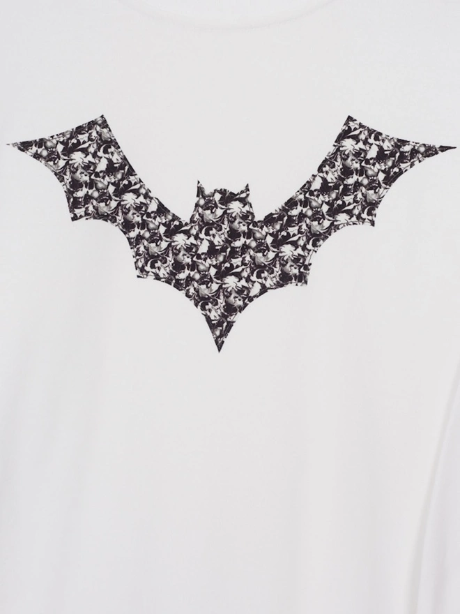 A white cotton t-shirt with a monochrome Liberty fabric bat sewn on the front.