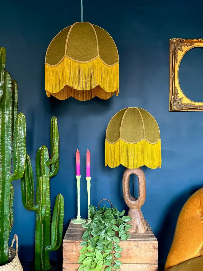 Fringed Hessian Lampshade In Pickle Green And Antique Gold, in a room. 