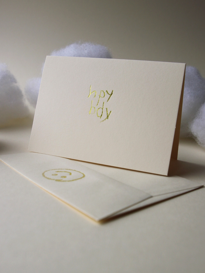 sandy coloured card with hpy bdy hand foiled in kids hand writing