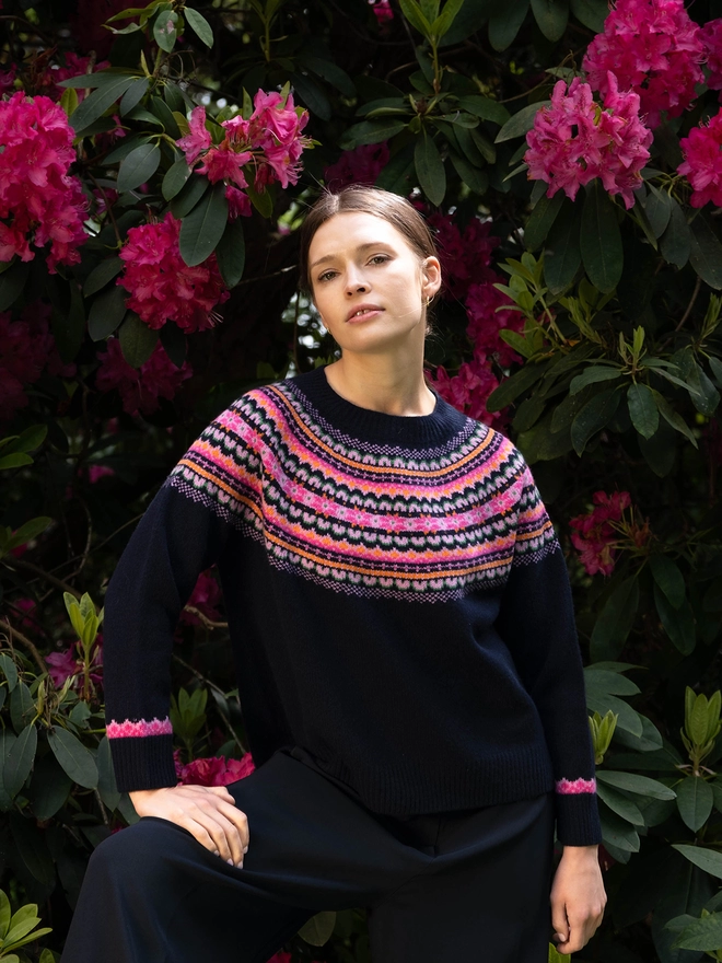 100% extra fine navy lambswool jumper with retro snowflake detailing in pink and orange. Detailing is placed around the yoke and cuffs of the garment.  