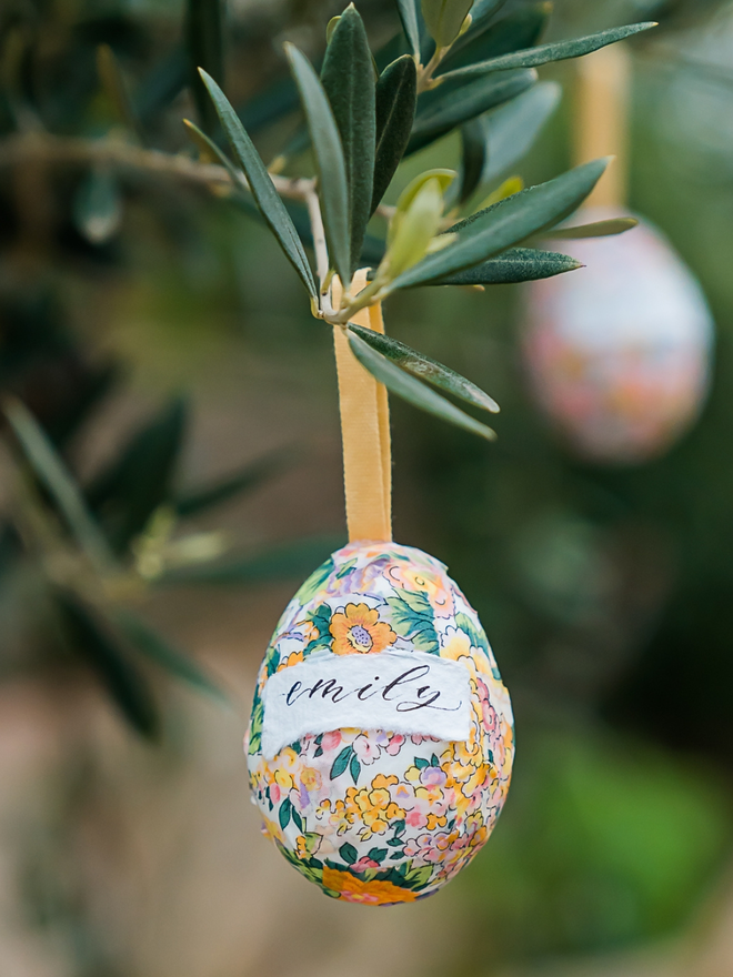Personalised liberty fabric decorative eggs hanging from a tree