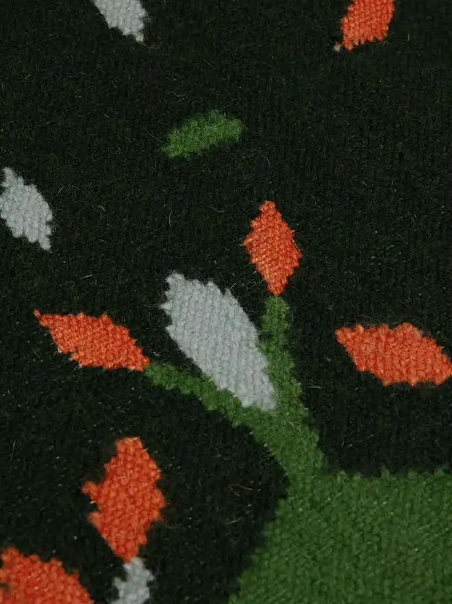 Hedgerow Flatweave Rug, a colourful rug sitting on a plain backdrop. 