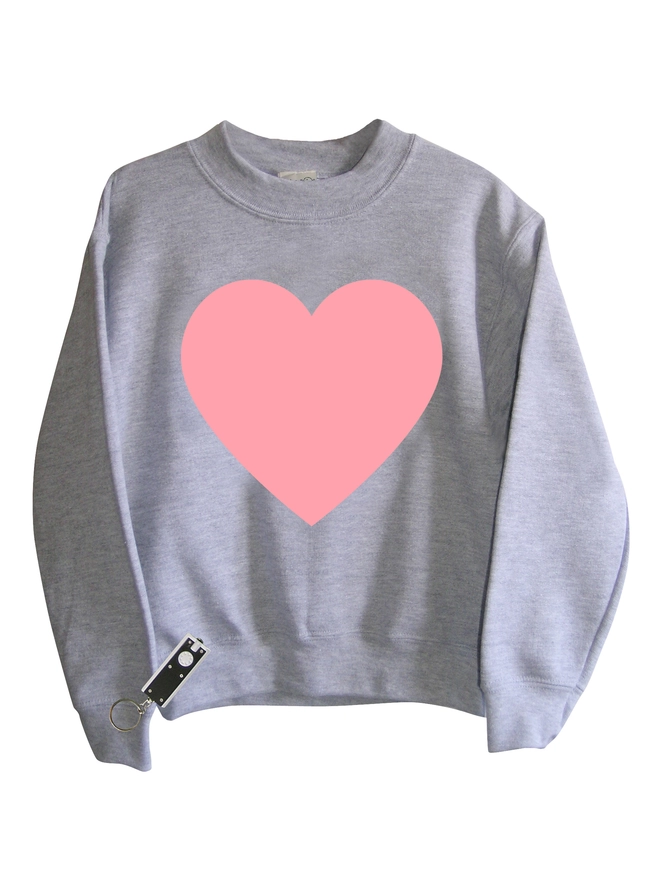 Grey sweatshirt with a large pink heart printed on it. Shown with a small penlight