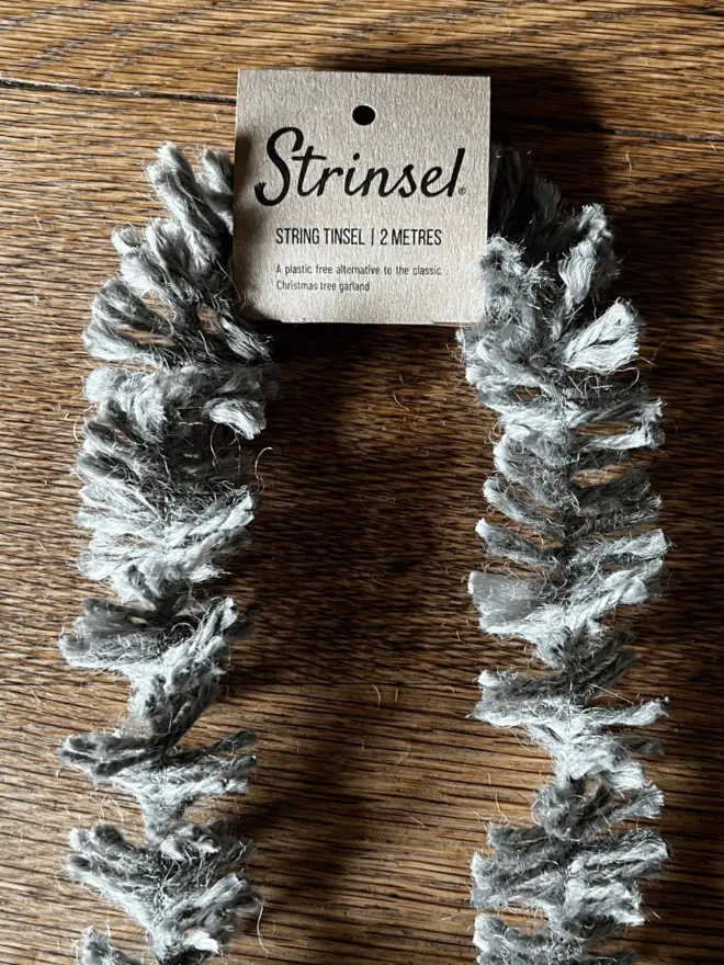 Classic Silver Strinsel with label AKA Jute string tinsel on an oak table