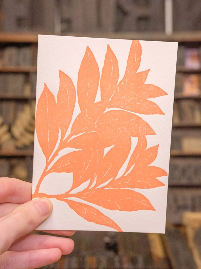 Front of card, held up. Situation shot. Orange bay leaf design.