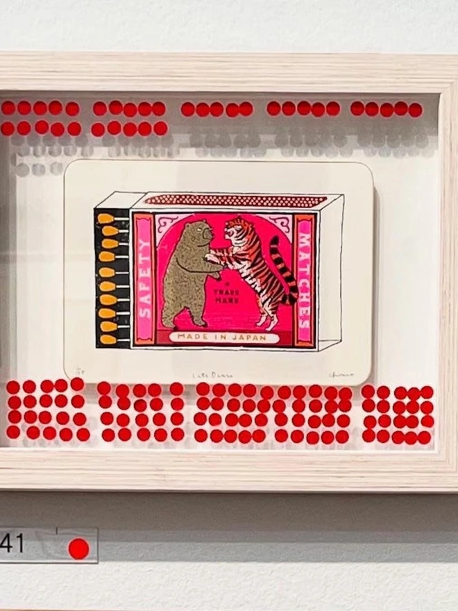 Bear And Tiger Matchbox Let's Dance, a colourful matchbox design on a white screenprint. It sits against a wall, framed, showing the bidding interest. 