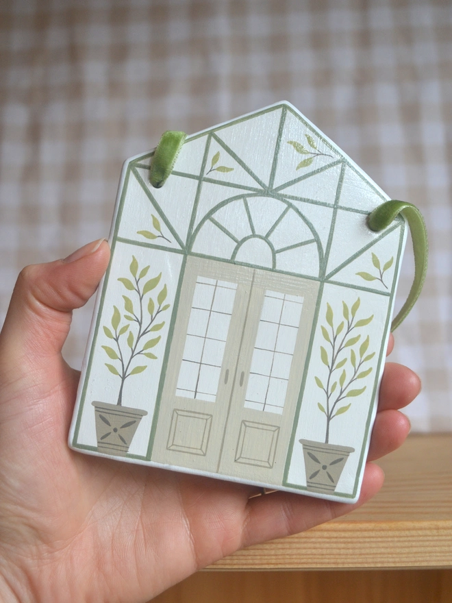 white ceramics hanging decoration with green greenhouse illustration design