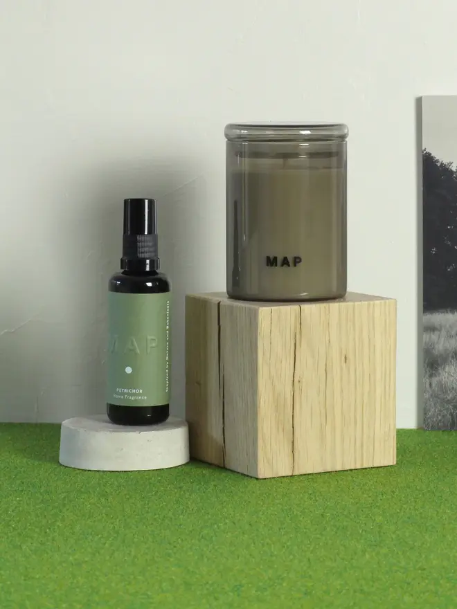 rest aromatherapy candle and home fragrance spray set. candle and spray bottle photographed on small wooden platforms.