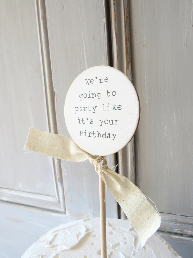 wooden circle shaped cake topper with hand painted message and custom ribbon