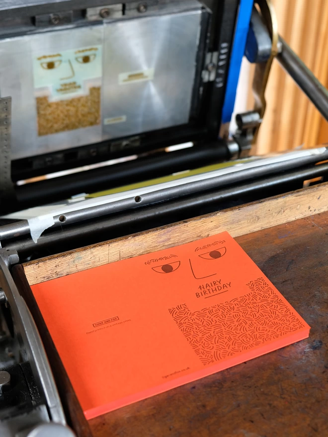 Tangerine 'Hairy Birthday' letterpress card on traditional printing press.