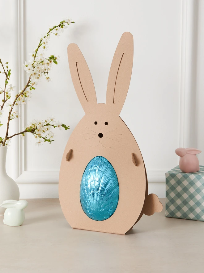 Maple & Pecan Dark Chocolate Easter Egg. a blue foil-wrapped easter egg inside a cardboard bunny. 