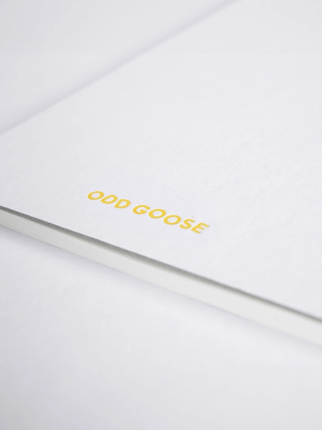 Odd Goose Daily Inventions Creative STEM notepad close up of yellow foil printed logo on back
