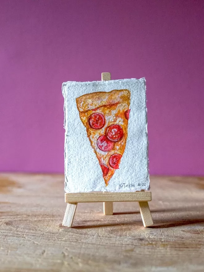 Katie Tinkler illustration of a pizza seen in front of a pink wall.