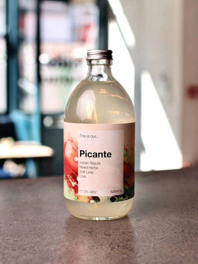 Bottle of Garden Picante on a concrete table, in a well lit interior room