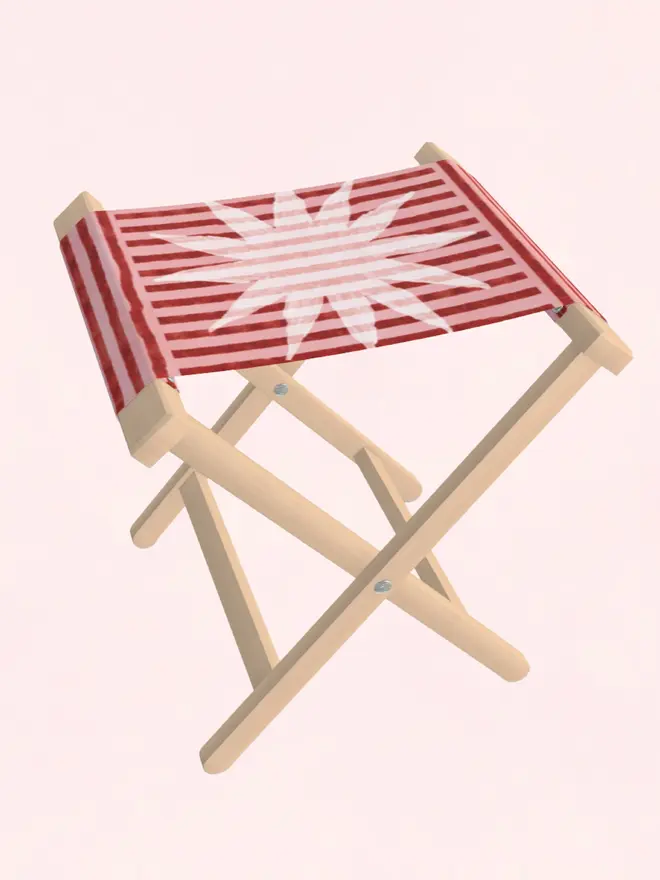 sun stripe folding stool. a burgundy and pink striped folding stool with a white sun motif.