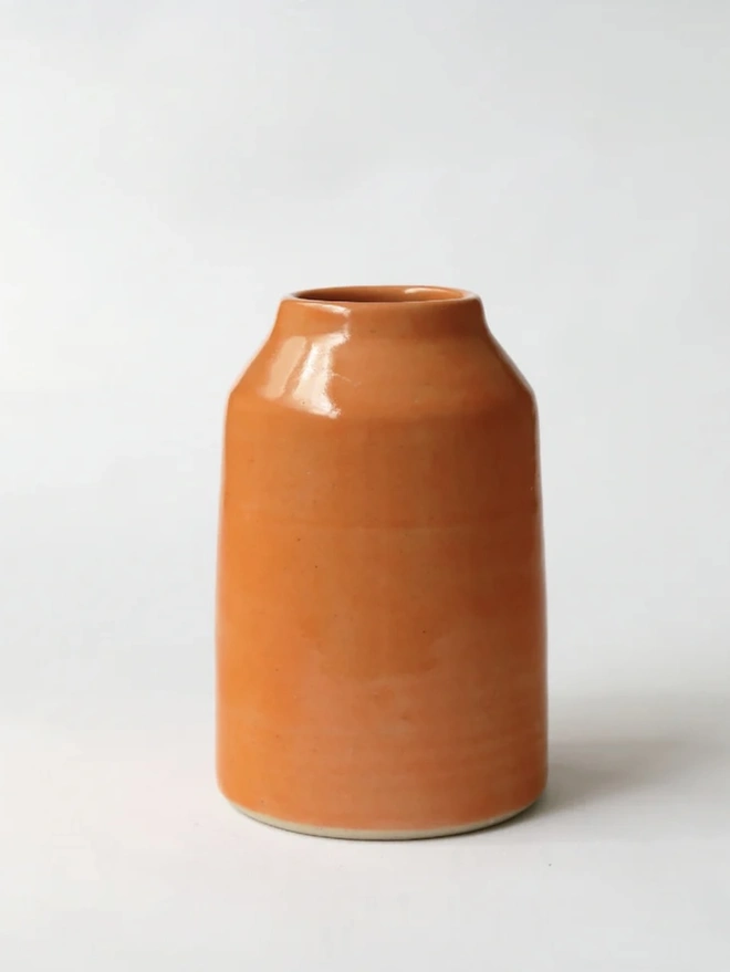 Classic Bud Vase, a colourful ceramic vase sitting on a plain surface against a white backdrop. 