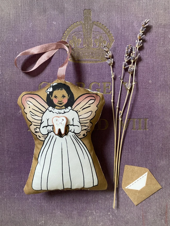 asian tooth fairy doll decoration holding a ceramic tooth button