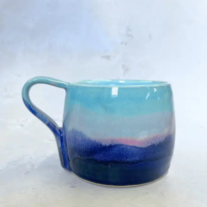 Landscape Large Round Mug, a colourful coffee mug on a stone surface. 