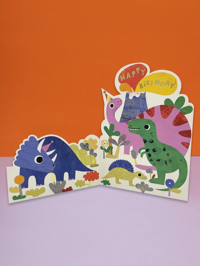 A vibrant dinosaur themed, die cut children’s birthday card, with colourful dinosaurs of all shapes and sizes. The card is complete with gold foil details and a gold foil ‘Happy Birthday’ message