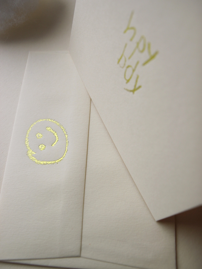sandy coloured card with hpy bdy hand foiled in kids hand writing