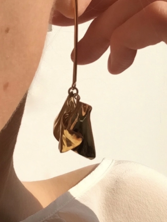 gold drop earrings handsculpted in the shape of petals affixed by a single bar