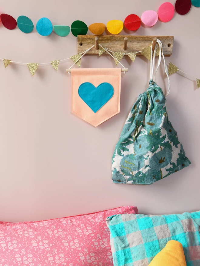 mini felt banner with blue heart hung from shelf.