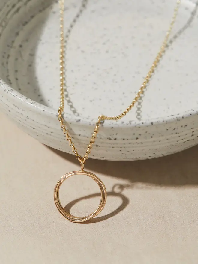 Circle Necklace hanging over a bowl