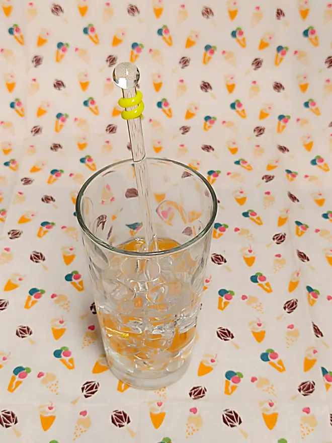Single yellow glass drinks stirrer in a glass
