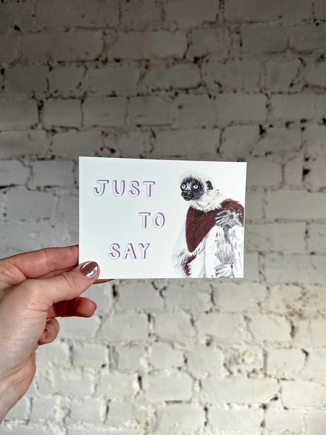  a greetings card featuring an illustration of a Coquerel’s Sifaka with the text “just to say”