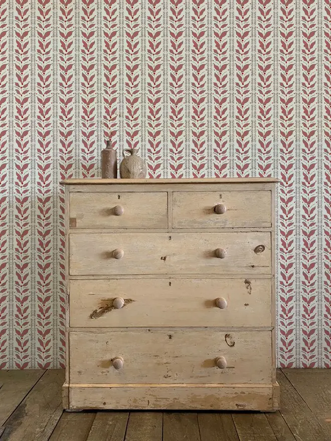 leaf stripe illustrated wallpaper. a burgundy leaf patterned wallpaper on a wall.