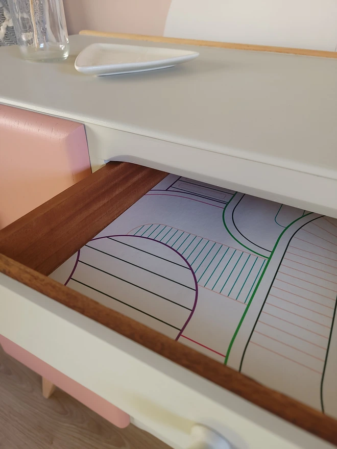 Top drawer on upcycled beige sideboard lined with paper