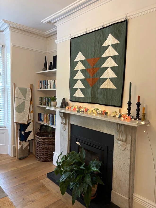 Flow sage linen throw quilt hung on wall in living room