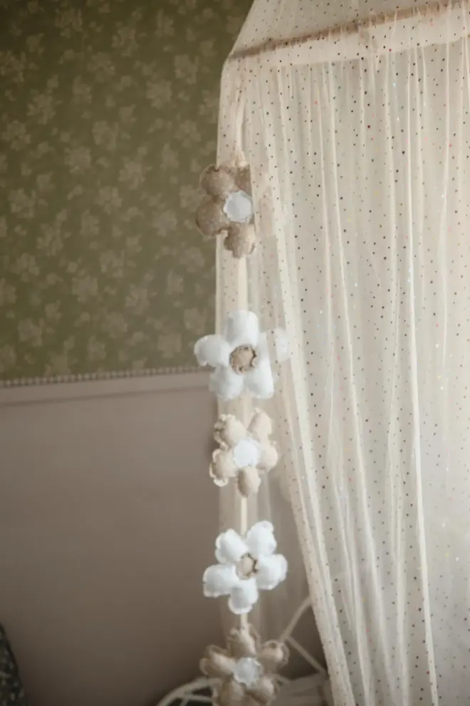 Daisy Flower Garland Decoration, a hanging colourful daisy flower garland sitting in a child's bedroom. 