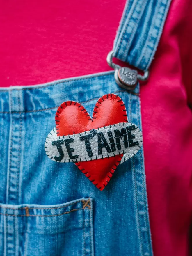 Red Heart Brooch seen on denim dungarees.