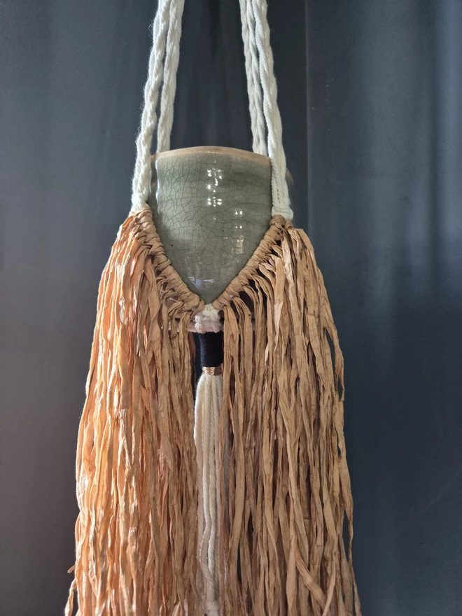 Handmade boho raffia paper plant hanger, adding texture and warmth to any space with a unique raffia fringe. stylish and modern hanging planter, perfect for indoor greenery and home decor trends