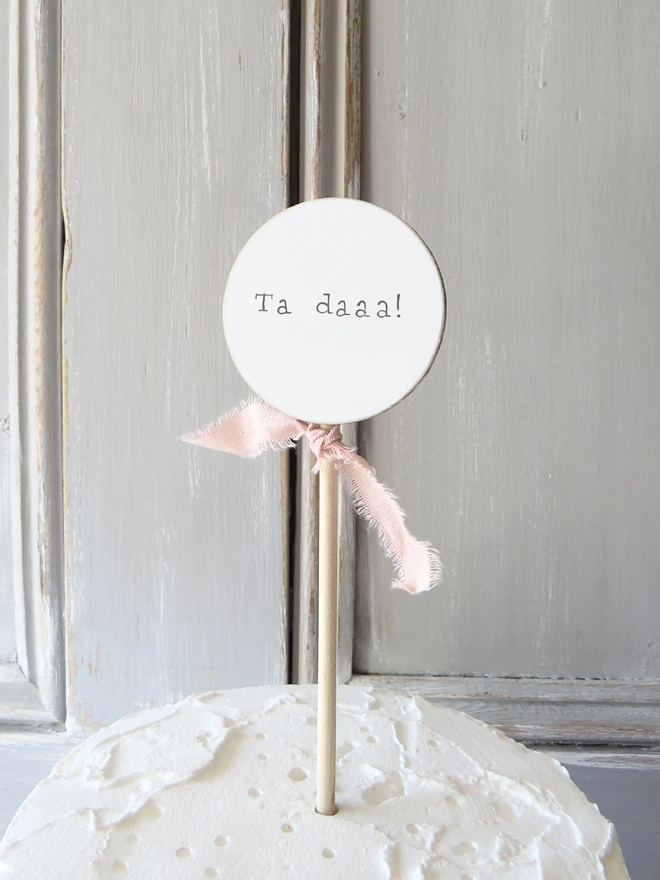 wooden circle shaped cake topper with hand painted message and custom ribbon