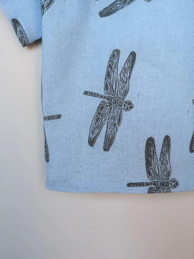 A lightweight soft pink popper down front shirt with charcoal grey Dragonfly print and short sleeves.