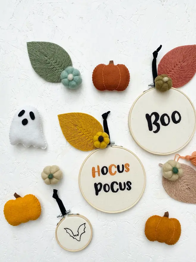 spooky phrase embroidered hoop. embroidered halloween hoops photographed with decorations.