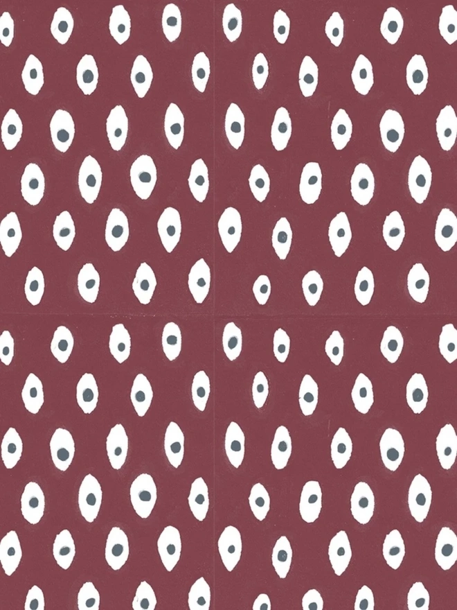 A5 Small Landscape Travel Watercolour Book. Close-up of a block-printed paper pattern with white oval spots and slate grey centres on a deep burgundy background. The bold repeat design suits notebooks, gift wrapping and decorative paper projects.