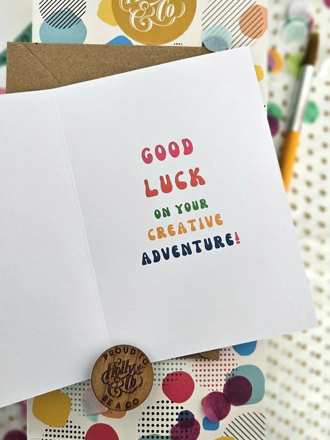 A colourful card using retro typography on a white background that says Good Luck on your creative adventure