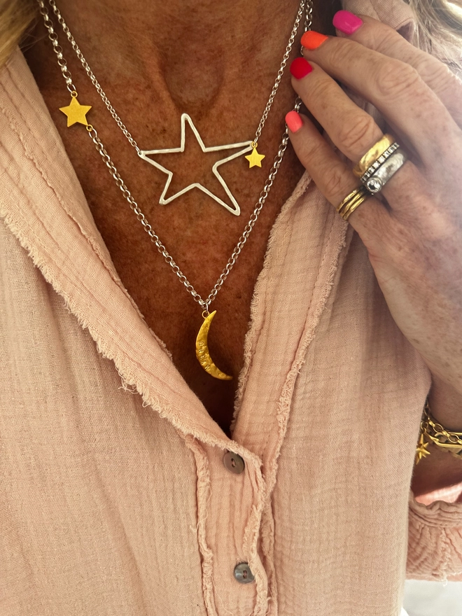 model wears a textured gold moon charm sits on a sterling silver heavy belcher chain, with linked gold cosmo star charm