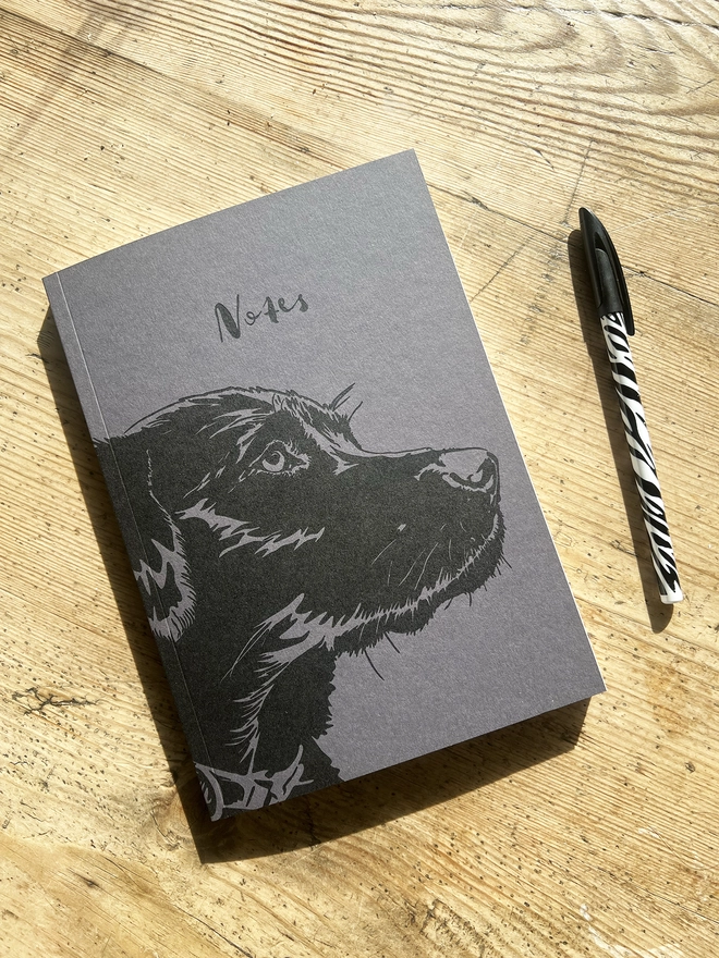 Labrador puppy note book with a pen next to it.