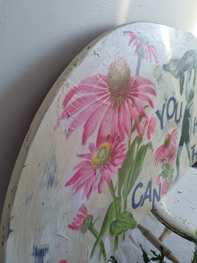 Art panel in a crescent shape made from a piece of vintage table top. Decorated with decoupage images of a man holding a crocodile aloft and pink flowers. The text reads 'you can do hard things'. The colours are cream with splashes of pink