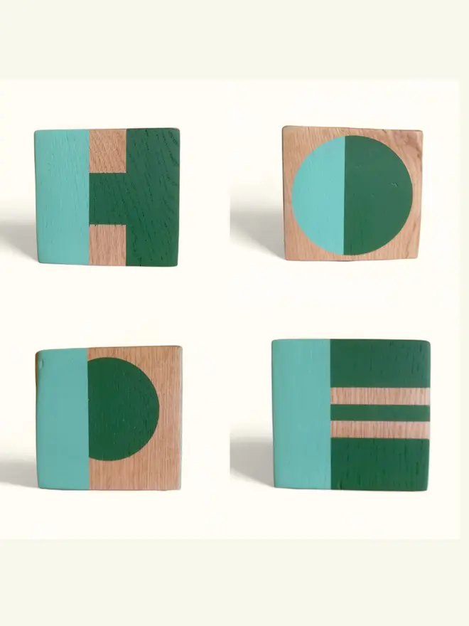 Four wooden cubes painted in green and mint with the letters H O P E