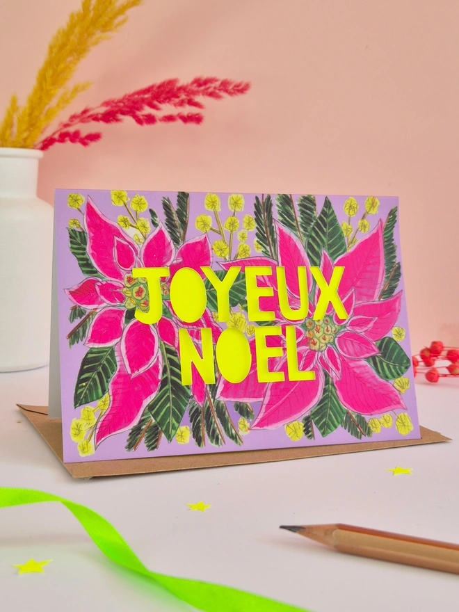 Pink poinsettia Christmas Card with paper cut Joyeux Noel text and neon yellow backing paper 