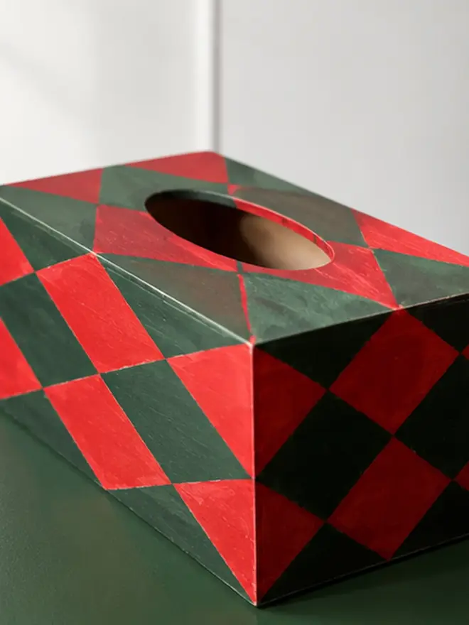 hand-painted harlequin tissue box. a tissue box in red and green painted harlequin pattern.